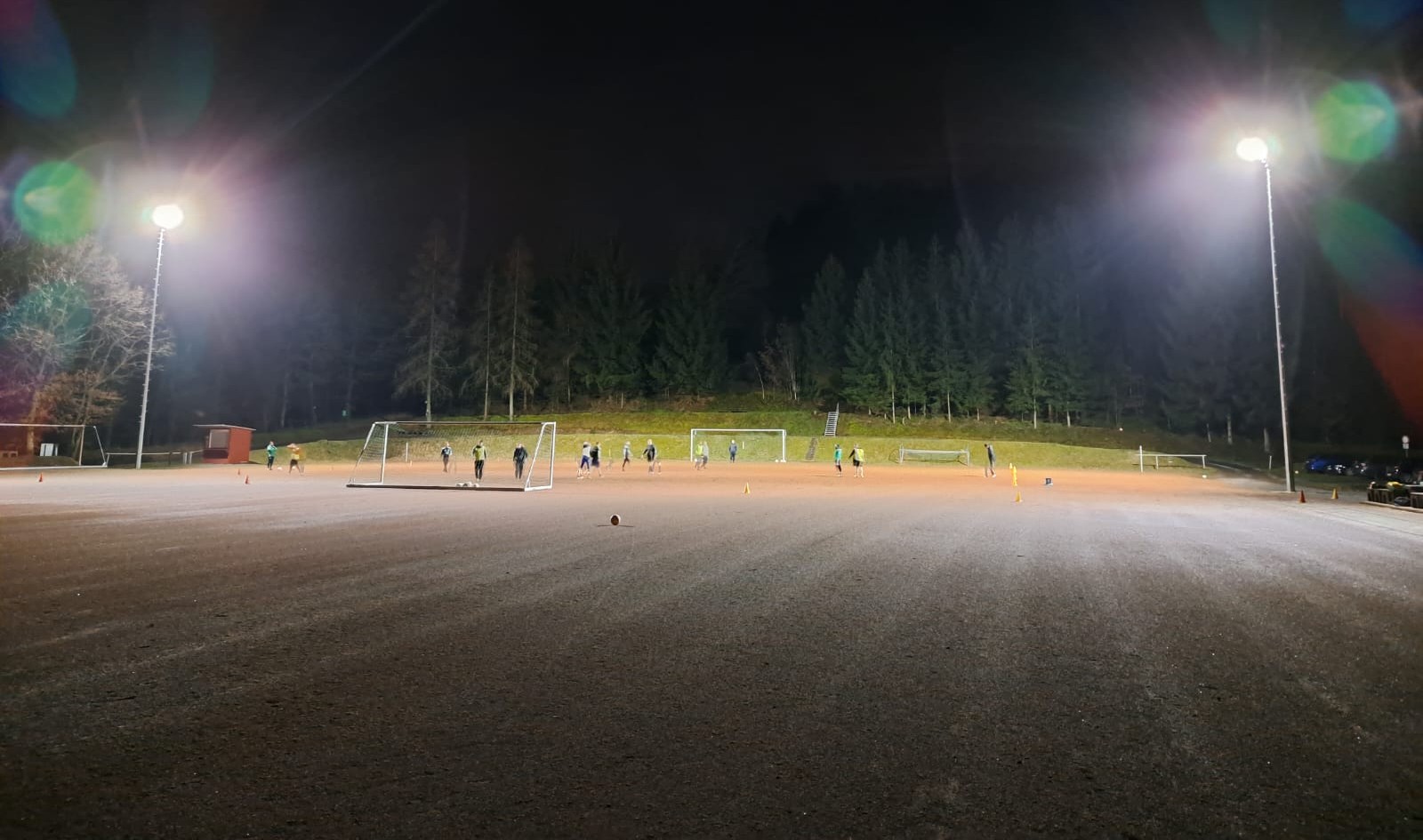 Das Flutlicht leuchtet über dem Sportplatz, auf dem die Mannschaft trainiert.
